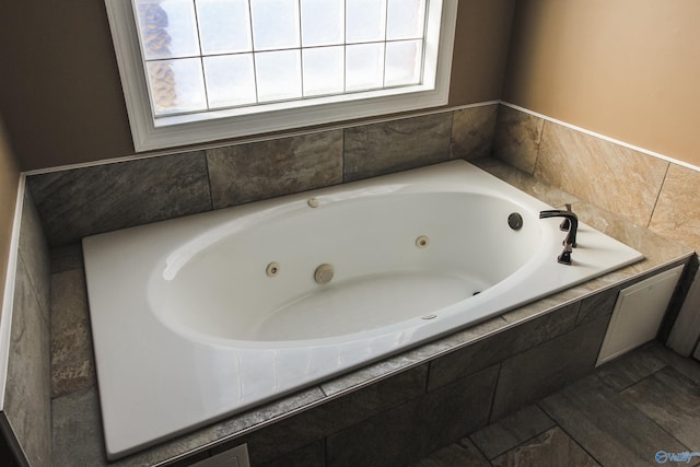 bathroom featuring tiled tub and a healthy amount of sunlight