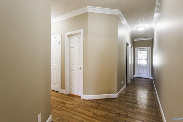 hallway featuring a textured ceiling, crown molding, and dark wood-type flooring