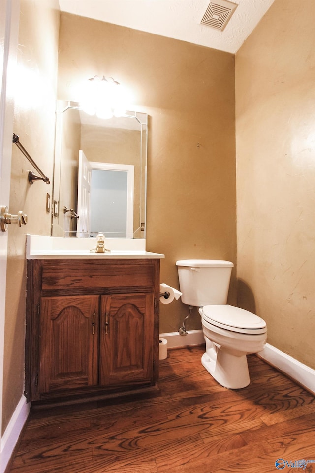 bathroom featuring hardwood / wood-style flooring, vanity, and toilet