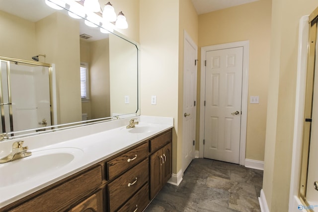 bathroom featuring a shower with door and vanity