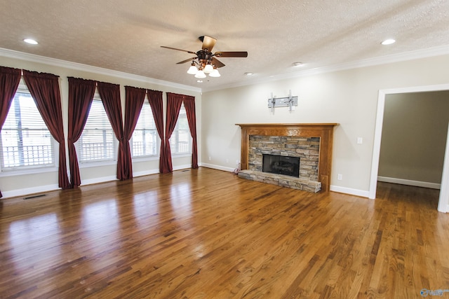 unfurnished living room with ceiling fan, ornamental molding, a fireplace, a textured ceiling, and dark hardwood / wood-style flooring