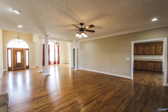 unfurnished living room featuring dark hardwood / wood-style flooring, decorative columns, ornamental molding, ceiling fan with notable chandelier, and a textured ceiling