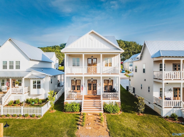 view of front of house with covered porch, a balcony, and a front yard