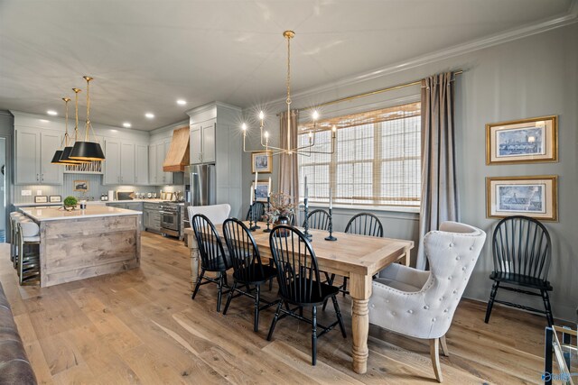 dining room featuring light hardwood / wood-style floors, a notable chandelier, and ornamental molding