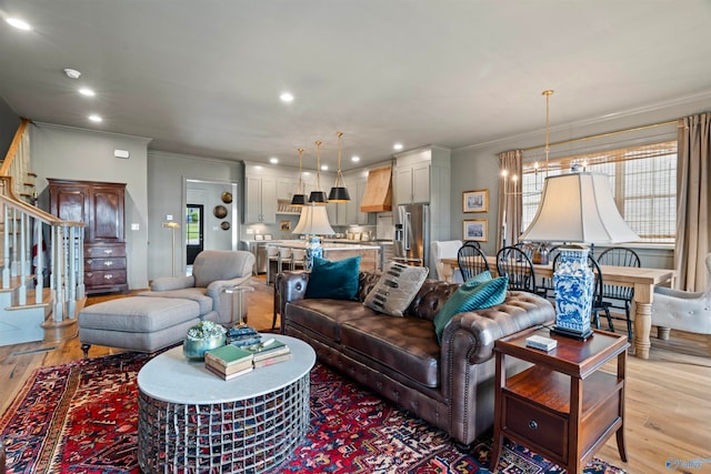 living room with plenty of natural light, crown molding, and light hardwood / wood-style flooring