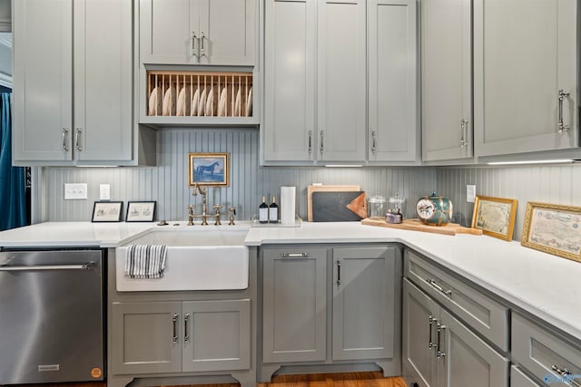 kitchen with gray cabinetry, light hardwood / wood-style floors, sink, and stainless steel dishwasher