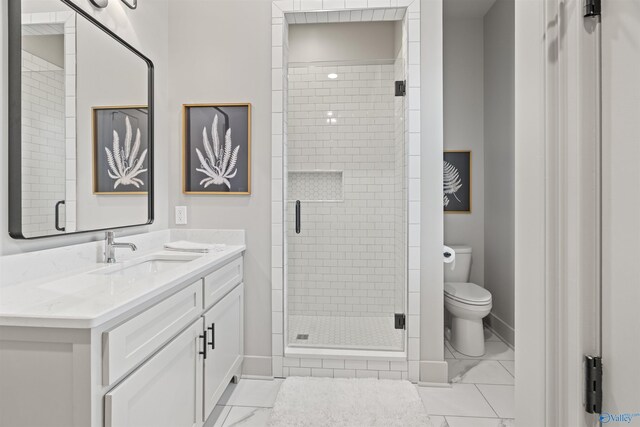 bathroom featuring a shower with shower door, vanity, tile patterned flooring, and toilet