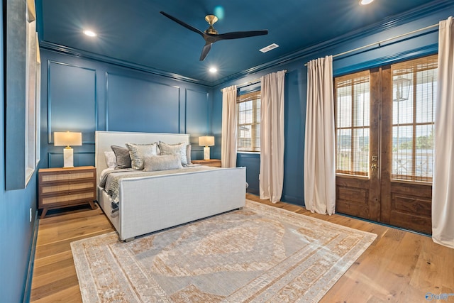 bedroom featuring multiple windows, ceiling fan, crown molding, french doors, and light hardwood / wood-style flooring