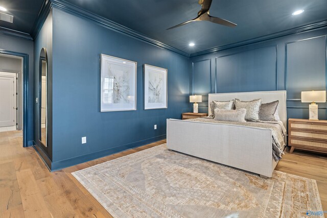 bedroom featuring crown molding, light hardwood / wood-style flooring, and ceiling fan