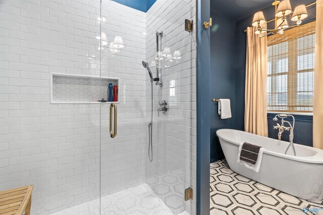 bathroom featuring tile patterned floors, a notable chandelier, and separate shower and tub