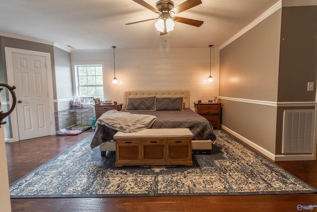 bedroom featuring ornamental molding, wood finished floors, visible vents, and baseboards