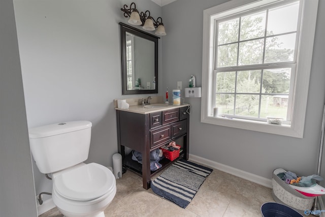 bathroom featuring baseboards, vanity, and toilet