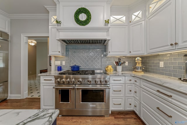 kitchen featuring crown molding, hardwood / wood-style flooring, backsplash, and premium appliances