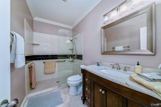 bathroom with vanity, a tile shower, toilet, ornamental molding, and tile patterned floors