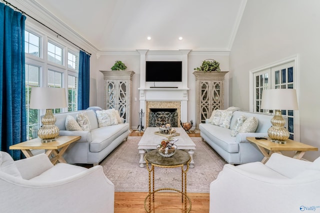 living room featuring crown molding, light hardwood / wood-style flooring, and vaulted ceiling