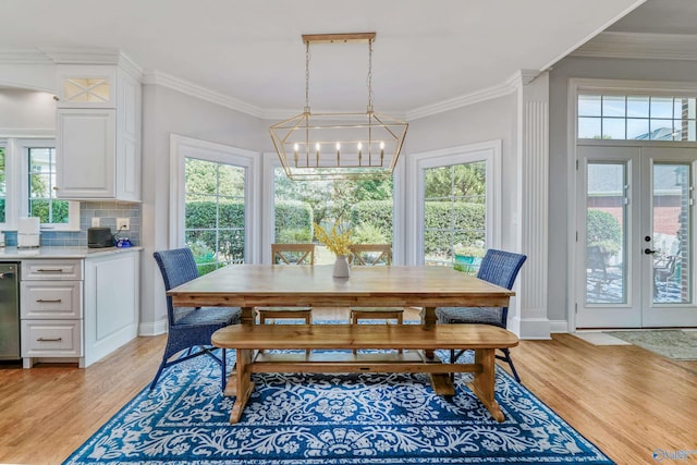 dining space with a wealth of natural light, light hardwood / wood-style floors, and ornamental molding