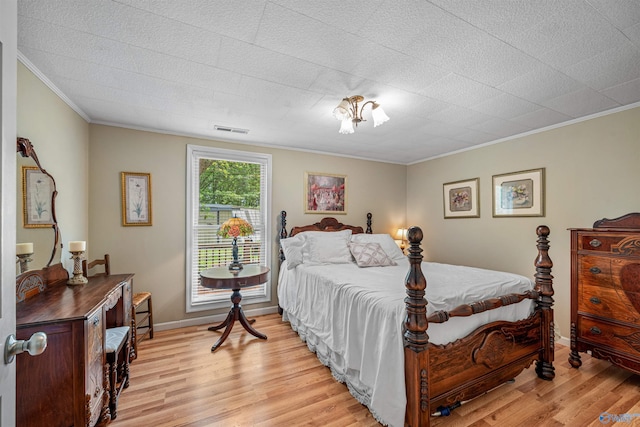 bedroom featuring visible vents, crown molding, baseboards, and light wood-style floors