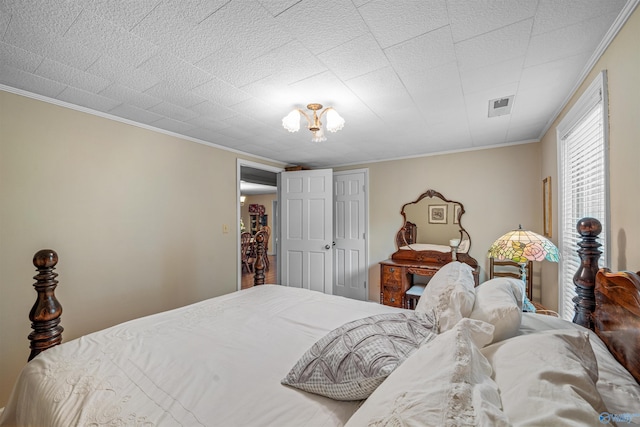 bedroom with ornamental molding, a closet, and visible vents