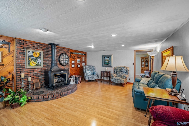 living room featuring a wood stove, wooden ceiling, and wood finished floors