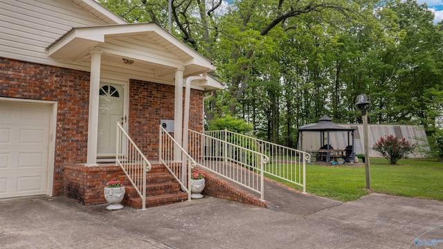 property entrance featuring a yard, brick siding, and a garage