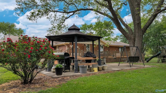 exterior space with a wooden deck, a gazebo, a lawn, playground community, and brick siding