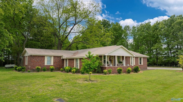 ranch-style house featuring a front lawn, metal roof, and brick siding