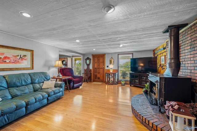living area with light wood finished floors and a wood stove