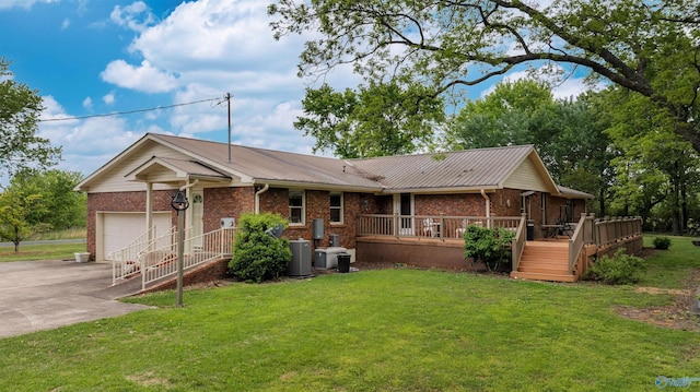 single story home with brick siding, metal roof, central AC, a front yard, and concrete driveway