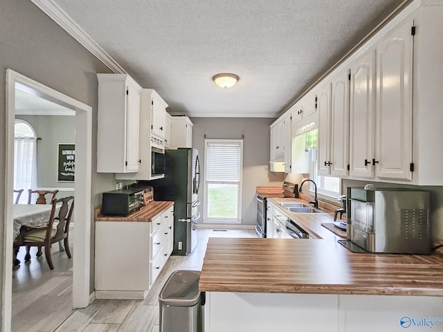 kitchen with white cabinets, kitchen peninsula, a textured ceiling, and appliances with stainless steel finishes