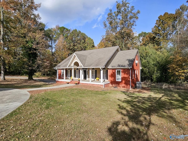 view of front of property featuring cooling unit, covered porch, and a front yard