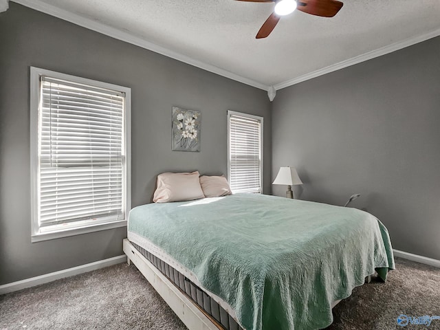 carpeted bedroom featuring multiple windows, ceiling fan, a textured ceiling, and ornamental molding