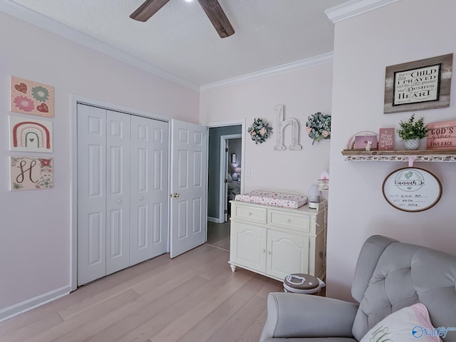 sitting room featuring ceiling fan, ornamental molding, a textured ceiling, and light hardwood / wood-style flooring