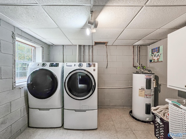 washroom featuring electric water heater, cabinets, and washer and dryer