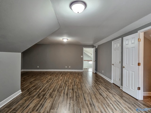 additional living space with hardwood / wood-style flooring and vaulted ceiling