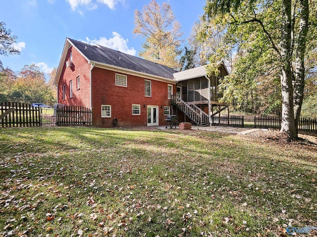 rear view of property with a sunroom and a lawn