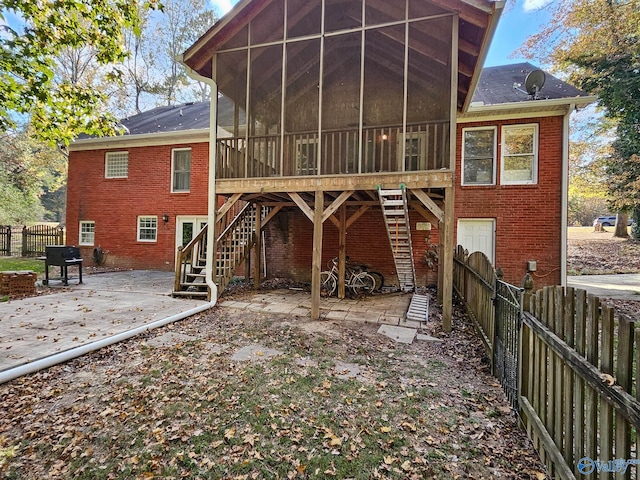 back of property with a patio area and a sunroom