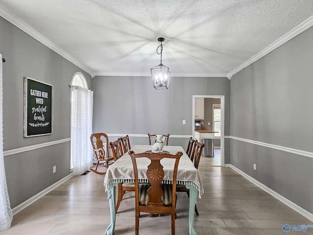 dining room featuring ornamental molding, a textured ceiling, hardwood / wood-style flooring, and a notable chandelier