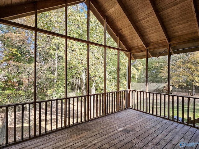 unfurnished sunroom with lofted ceiling with beams, plenty of natural light, and wooden ceiling