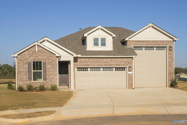 view of front facade featuring roof with shingles, concrete driveway, a front yard, a garage, and brick siding