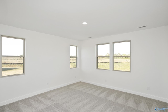 spare room with light carpet, visible vents, recessed lighting, and baseboards