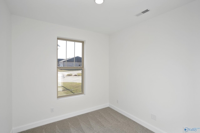 unfurnished room featuring visible vents, carpet, and baseboards