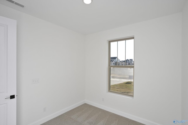 unfurnished room featuring carpet, visible vents, and baseboards