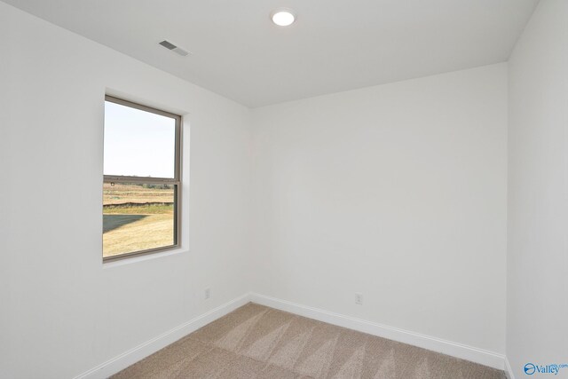 empty room with recessed lighting, visible vents, light colored carpet, and baseboards