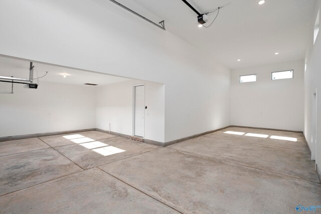 garage featuring recessed lighting, baseboards, and a garage door opener