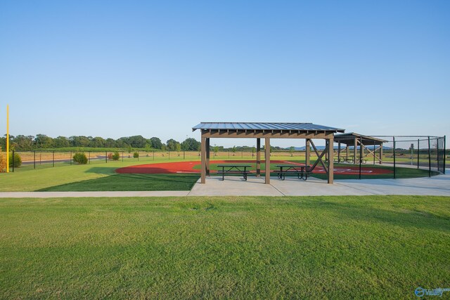 view of property's community featuring a gazebo, a lawn, and fence