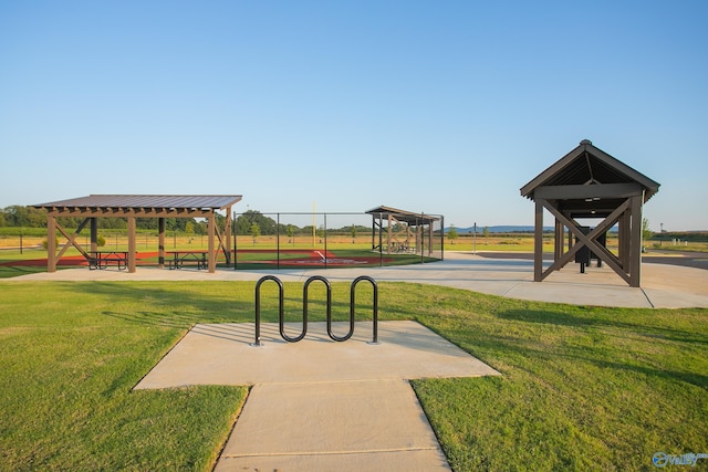 view of community featuring a gazebo, a lawn, and fence