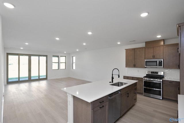 kitchen featuring light countertops, recessed lighting, appliances with stainless steel finishes, light wood-style floors, and a sink