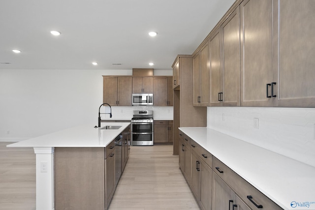 kitchen with a sink, stainless steel appliances, backsplash, and recessed lighting