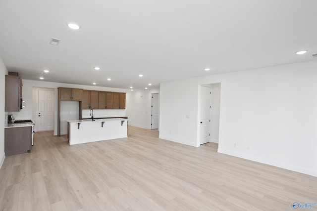 unfurnished living room with recessed lighting, visible vents, and light wood finished floors