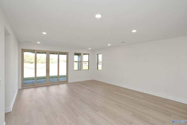 empty room featuring recessed lighting, a healthy amount of sunlight, and light wood-type flooring